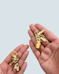 Minimalist butterfly orchid gold-tone studs displayed in hand - Trinketly BD