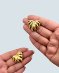 Hand-held view of gold-tone seashell bloom stud earrings - Trinketly BD